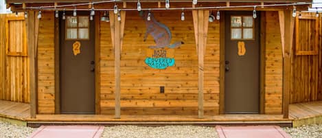 A wooden bathhouse with two covered wagons, each marked with a number.