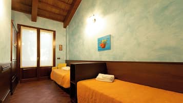 Una habitación de hotel con dos camas, cabeceros de madera y un cuadro en la pared.