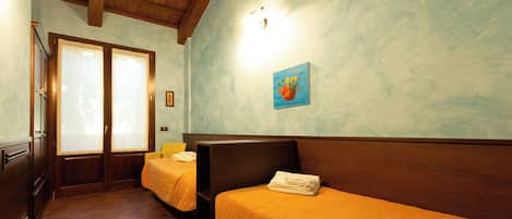Une chambre d’hôtel avec deux lits, des têtes de lit en bois et un tableau au mur.