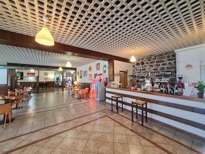 Un'ampia hall con angolo bar, diverse zone salotto e un soffitto decorato.
