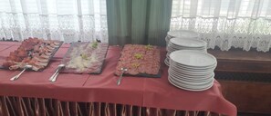 Ein Buffet mit verschiedenen Speisen und gestapelten Tellern.