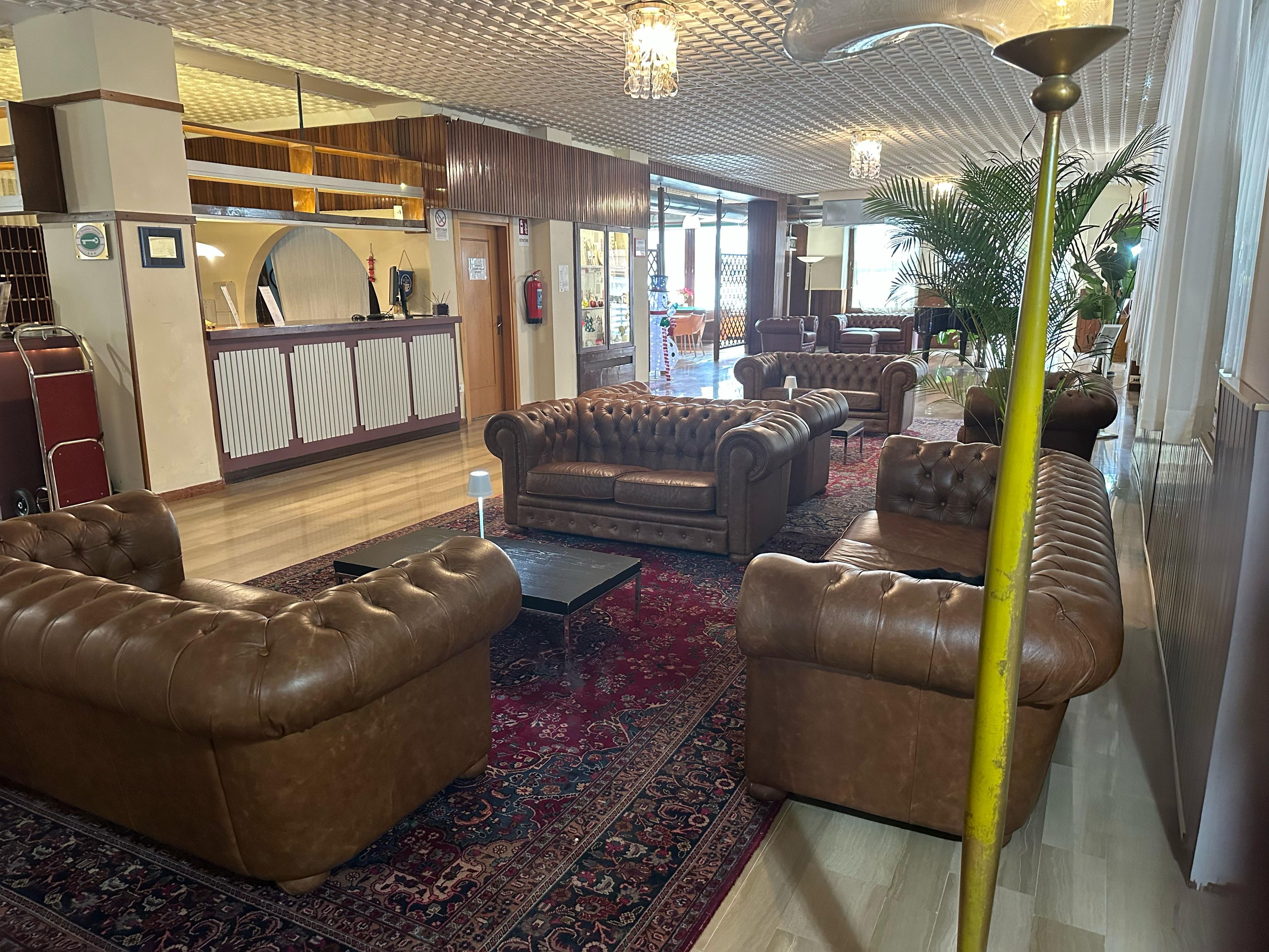 A lobby with leather sofas, a reception desk, and a patterned carpet.