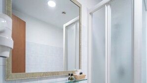 A bathroom with a white sink, a glass shelf with toiletries, a mirror, and a shower door. - Hotel Orizzonte (Letojanni)