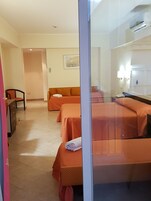 Habitación de hotel con dos camas, un escritorio, una silla y un baño.