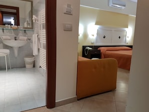 A hotel room with a bathroom, a bed, and a nightstand. - Hotel Orizzonte (Letojanni)