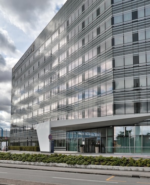 Ein modernes Hotelgebäude mit Glasfassade und einem markanten Eingang.