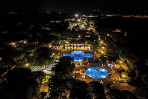 A resort with multiple swimming pools, a large building with a dome, and surrounding landscaped areas.