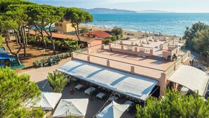 Terraza en la azotea con mobiliario exterior, con vistas a una playa y al mar.