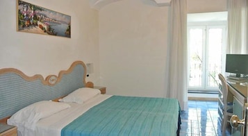 A bedroom with a bed, a painting, a television, and a window.