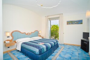 A bedroom with a bed, a television, and a window with a view. - Albergo Italia (Casamicciola Terme)