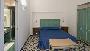 Ein Schlafzimmer mit Bett, Nachttischen, einer Bank und einem Kleiderschrank.