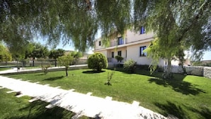 A two-story building with a garden in front. - Arucimeli Resort (Ragusa)