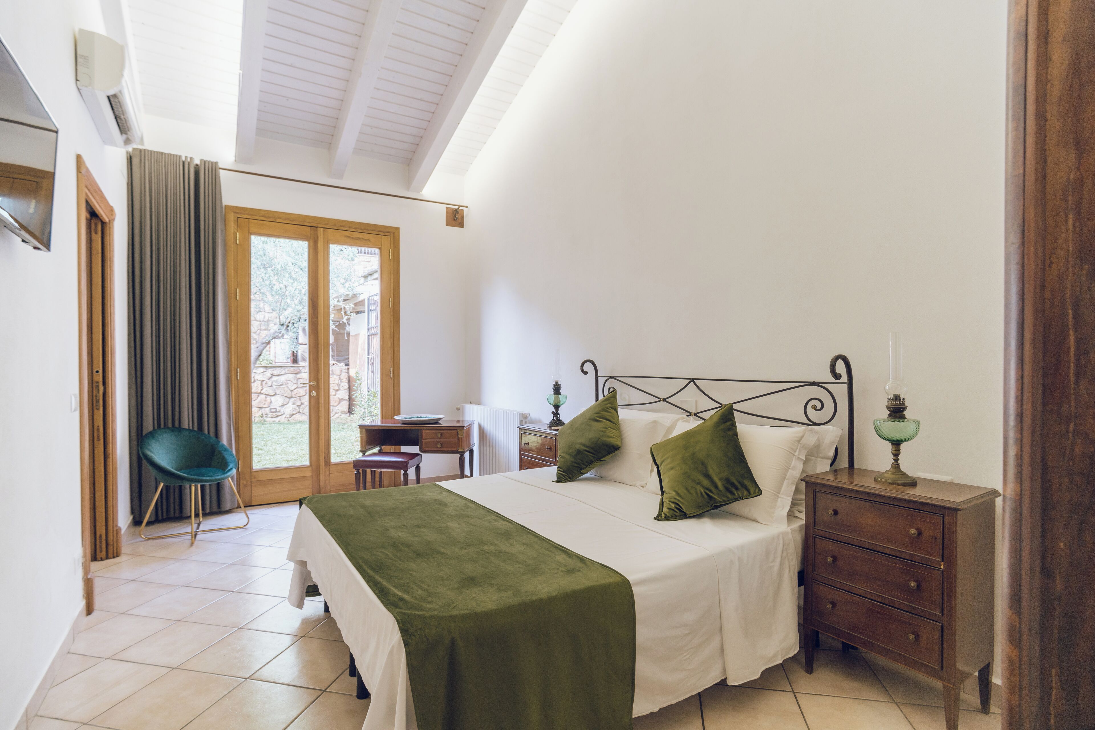 A bedroom with a bed, a nightstand, a chair, and a desk.