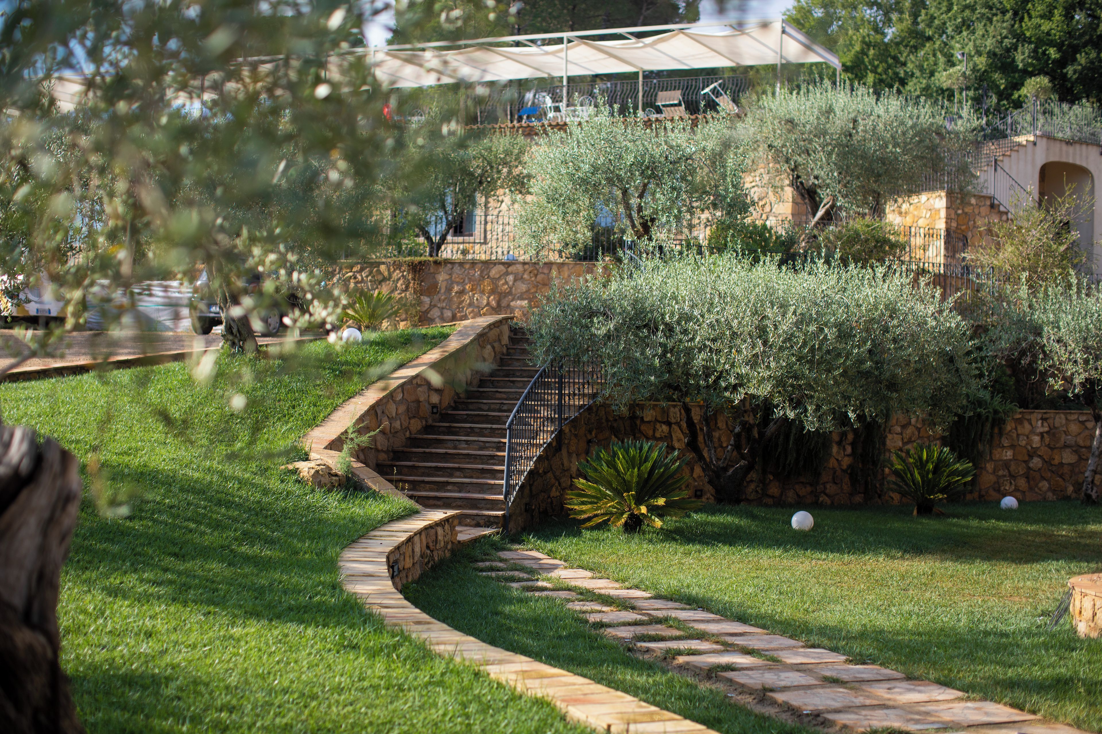 A stone staircase leading to a building with a covered outdoor seating area.
