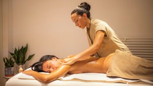Une séance de massage thérapeutique dans un cadre de spa, avec une table de massage, un client et un thérapeute.