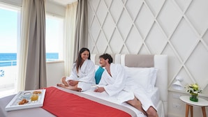 A hotel room with a bed, a tray with breakfast, a window with curtains, and a view of the sea. - Grand Hotel Riviera CDS Hotels (Nardò)