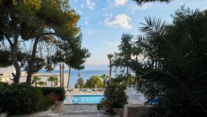 A pool area with steps leading down to the water, surrounded by trees and a view of the sea. - Grand Hotel Riviera CDS Hotels (Nardò)