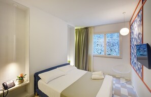 A hotel room with a bed, a desk with a telephone, a chair, a TV, and a window with curtains. - Grand Hotel Riviera CDS Hotels (Nardò)