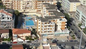 Vue aérienne d’un quartier résidentiel comprenant plusieurs immeubles d’appartements, une piscine et un parking.
