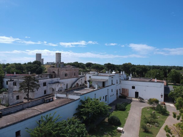 Un patio con edificios blancos, un sendero pavimentado y follaje.