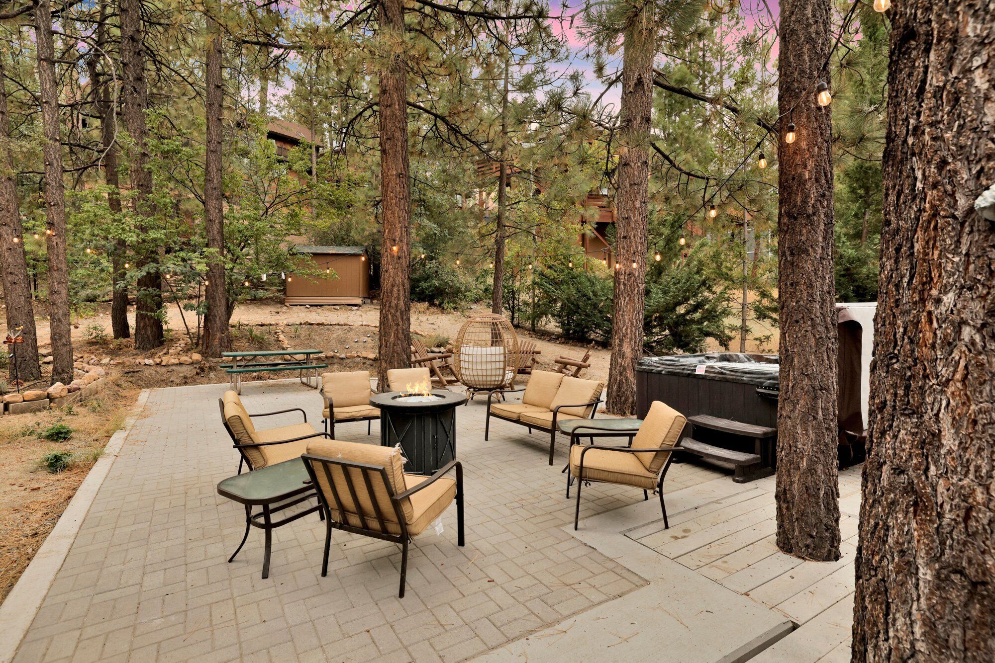 Un espacio al aire libre con zona de estar, una chimenea y un jacuzzi.