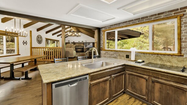 Une cuisine moderne dotée d’un grand îlot central, de meubles en bois et d’un lave-vaisselle.