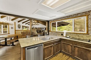 Cozinha moderna com uma ilha grande, armários de madeira e lava-louças.