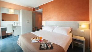 A hotel room with a large bed, a desk, and a wardrobe. There is a breakfast tray on the bed. - Testani Colleferro (Colleferro)
