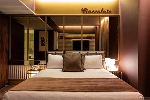 Une chambre d’hôtel avec un lit, une table de chevet, une lampe et un miroir.