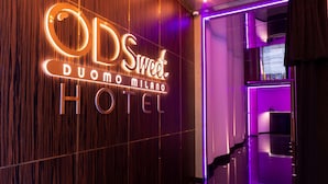 Een hotelscherm met de naam 'ODS Sweet Duomo Milano Hotel' in verlichte letters.