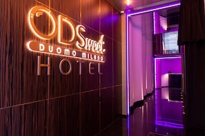 Une enseigne d’hôtel avec le nom « ODS Sweet Duomo Milano Hotel » écrit en lettres lumineuses.