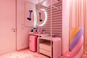 A pink-themed room with a vanity, mirror, and a small refrigerator. - Odsweet Duomo Milano Hotel (Milan)