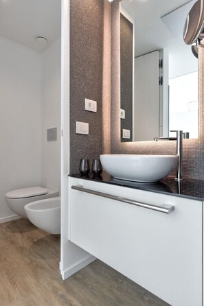 A modern bathroom with a large white sink, a bidet, and a toilet. - Innside Milano Torre Galfa (Milan)