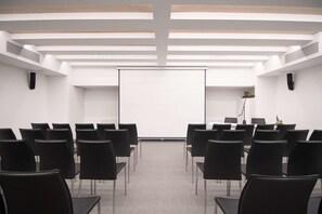 A conference room with a whiteboard, black chairs, and a wooden ceiling. - Innside Milano Torre Galfa (Milan)