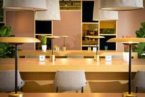 A modern conference room with a long table, several chairs, and pendant lighting. - Innside Milano Torre Galfa (Milan)