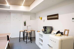 A modern office space with a ping pong table, bar stools, a coffee machine, and a vintage refrigerator. - Innside Milano Torre Galfa (Milan)