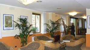A lobby with wicker furniture, large potted plants, and artwork on the walls. - Hotel San Pietro Beach - Letojanni (Letojanni)