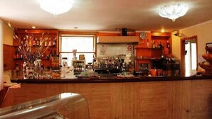 A kitchen with wooden cabinets, a countertop with various items, a window, and a clock on the wall.