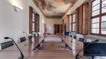 Une salle de conférence équipée d’une longue table, de nombreuses chaises, de microphones et d’ordinateurs.