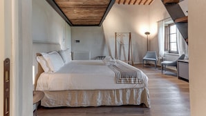 Una camera da letto con un letto grande, un termosifone, una sedia, una scrivania e una finestra.