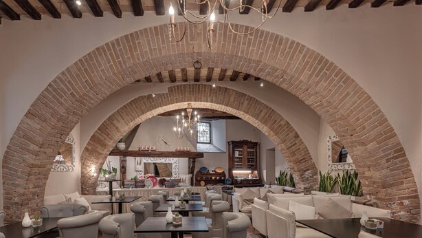 A cozy, rustic interior with arched brick ceilings, comfortable seating, and a warm ambiance. - B&B Borgo Medievale San Quirico D'orcia (San Quirico d'Orcia)