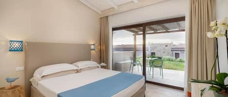 Un dormitorio con cama, mesita de noche, lámpara, ventana con cortinas y vista al exterior.