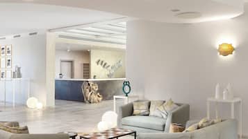 A modern lobby with a reception desk, seating area, and a large abstract artwork on the wall.
