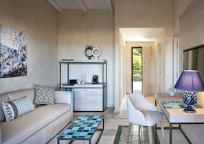 Un salon moderne avec un canapé, une table basse et un coin repas agrémenté d’une lampe.