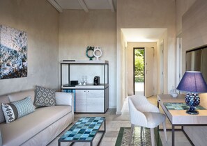 Ein modernes Wohnzimmer mit Sofa, Couchtisch und Essbereich mit Lampe.
