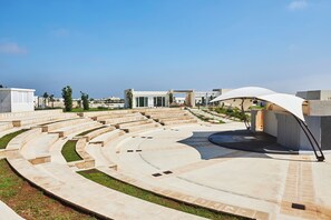 A modern outdoor amphitheater with tiered seating and a covered stage area. - Relais Masseria Le Cesine Cdshotels (Vernole)