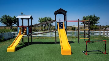 A playground with two slides and a climbing structure.