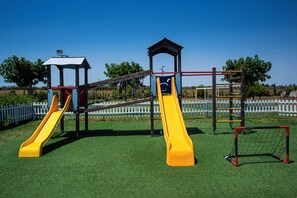 Ein Spielplatz mit zwei Rutschen und einer Kletterstruktur.