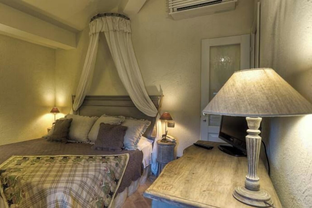 Une chambre à coucher avec un lit, une table de chevet avec une lampe et un lit à baldaquin.