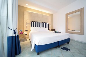 Una camera da letto moderna con un letto grande, una testiera a righe, un comodino con una lampada e un grande specchio a parete.